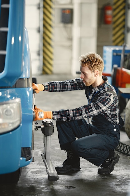 Automechaniker repariert Auto in Garage mit Werkzeugen