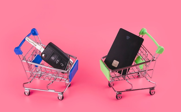 Kostenloses Foto autoschlüssel und reisekarte in der blauen und grünen einkaufskarte gegen rosa hintergrund