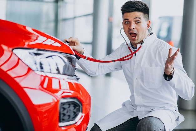 Autotechniker mit Stethoskop in einem Autosalon