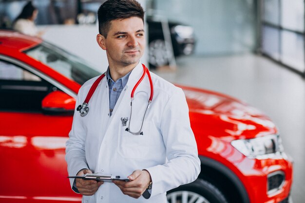 Autotechniker mit Stethoskop in einem Autosalon