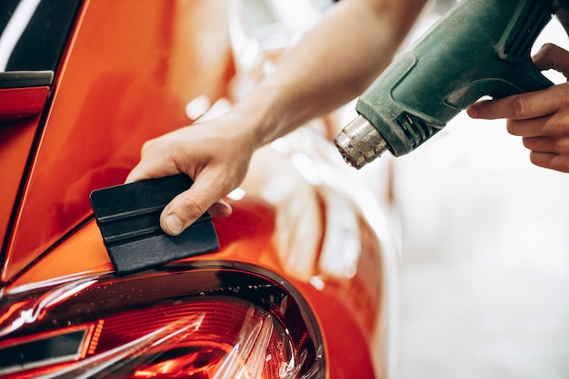 Autoverklebung mit Folie und Trocknung mit Ventilator beim Autoservice