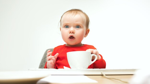 Baby, das mit Tasse Kaffee sitzt