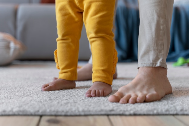 Baby lernt mit der Hilfe seiner Mutter laufen