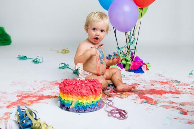 Baby Mädchen feiert ihre erste bithday mit Gourmet Kuchen und ba