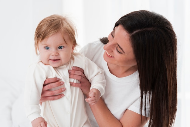 Baby posiert, während von der Mutter gehalten