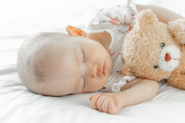 Baby schläft mit einem Teddybär
