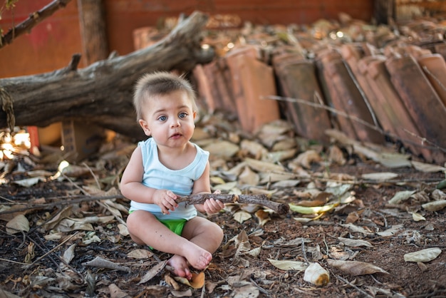 Baby sitzt auf dem hinterhof boden Premium Fotos