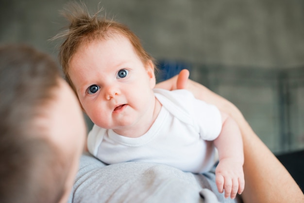 Baby von schönen Vater umarmt