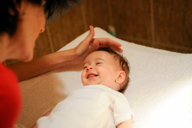 Baby zwei Monate alte, die zu Hause zu ihrer Mutter lächeln