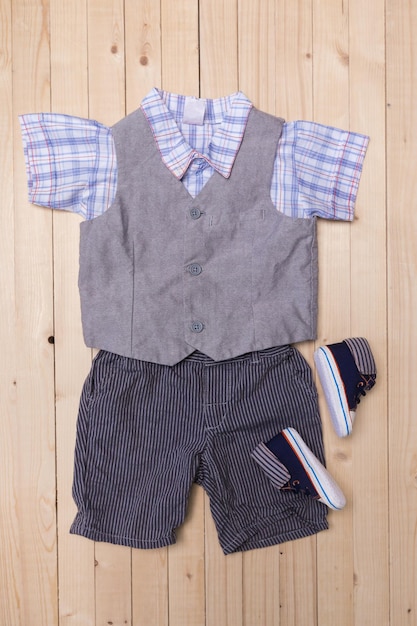 Babykleidung für Jungen auf Holzuntergrund