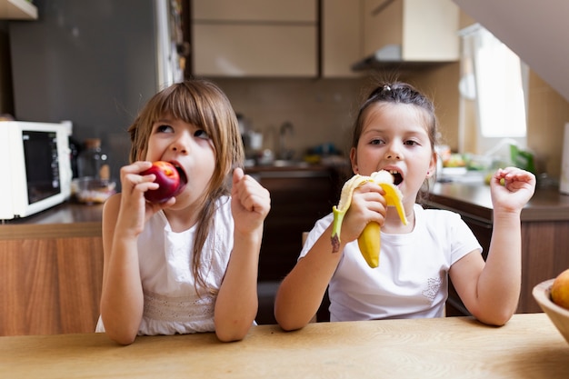 Kostenloses Foto babyschwestern, die einen gesunden imbiß essen