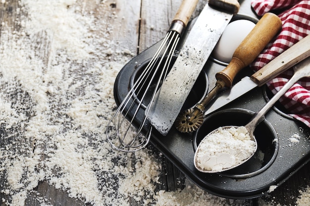 Backen Konzept Küche Kochen Besteck Zubehör für Backen auf Holzuntergrund mit Mehl. Draufsicht. Kochprozess. Niemand.