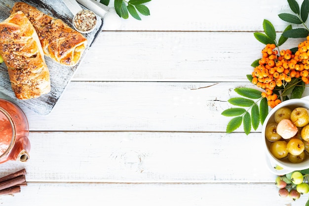 Kostenloses Foto backen mit apfel frisch gebackener apfel und zimtbrötchen aus blätterteig auf einem weißen holztisch draufsicht rustikaler kopierraum