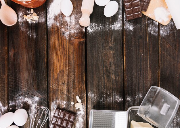 Backende Kuchenzutaten mit Küchengerät auf die Holztischoberseite