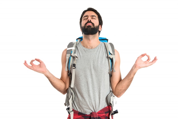 Backpacker in Zen-Position auf weißem Hintergrund