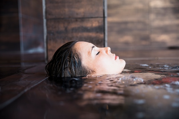 Badekurortkonzept mit der Frau, die im Wasser sich entspannt