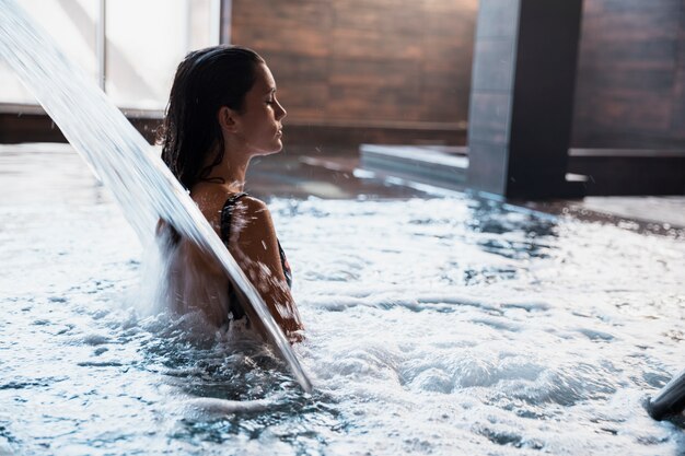 Badekurortkonzept mit der Frau, die im Wasser sich entspannt