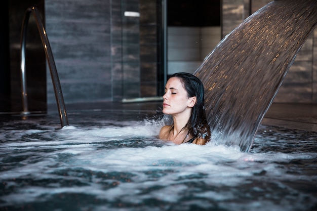 Badekurortkonzept mit der Frau, die im Wasser sich entspannt