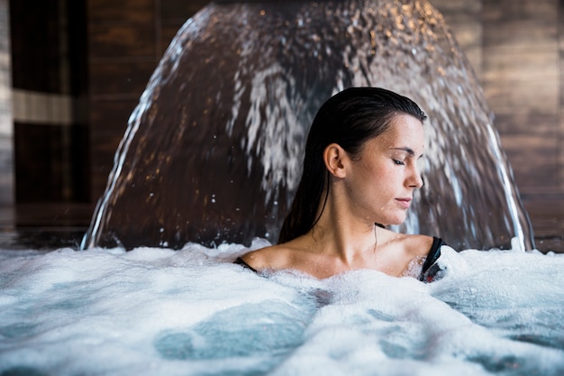 Badekurortkonzept mit der Frau, die im Wasser sich entspannt