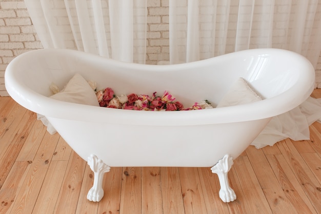 Kostenloses Foto badewanne voll blumen im minimalistic innenraum mit backsteinmauerhintergrund