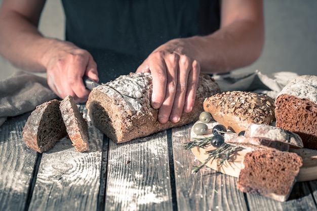 Bäcker, der frisches Brot in den Händen hält