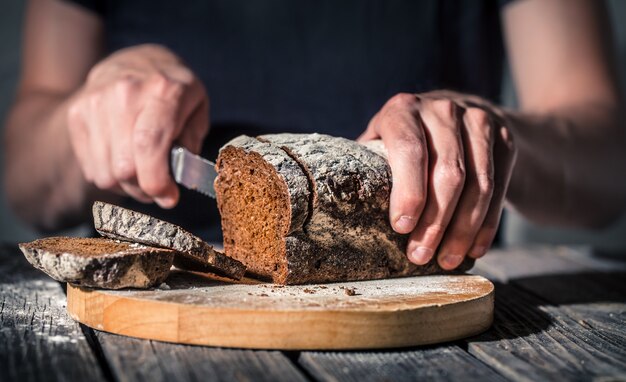 Bäcker, der frisches Brot in den Händen hält