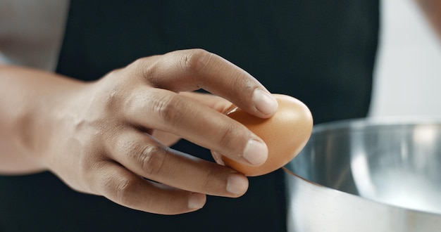 Kostenloses Foto bäcker gemischter rassen macht einen kuchen, der eier zerschmettert