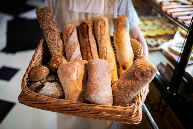 Bäcker hält Korb mit Brotstangen hautnah