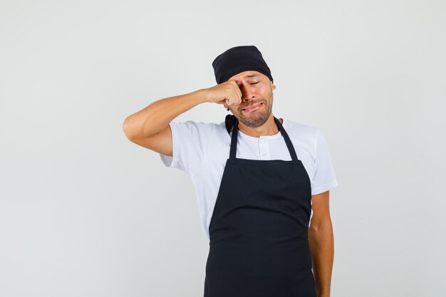 Bäcker-Mann, der Augen reibt, während er im T-Shirt weint