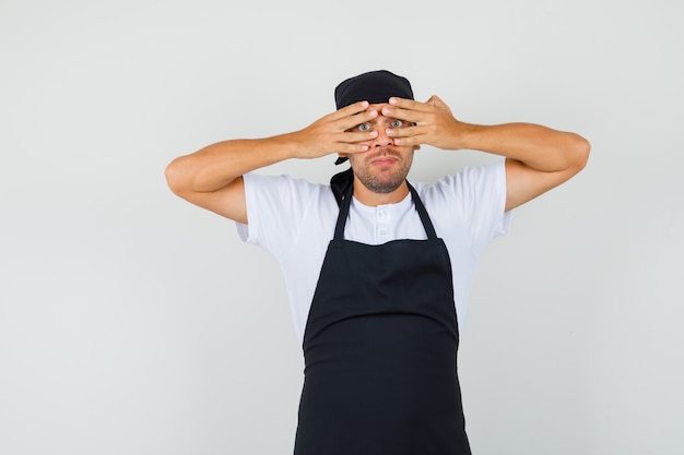 Bäcker Mann, der durch Finger im T-Shirt schaut