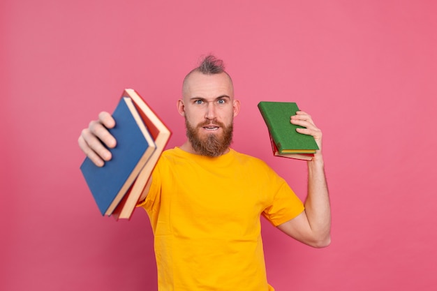 Bärtiger europäischer mann mit stapel bücher auf rosa