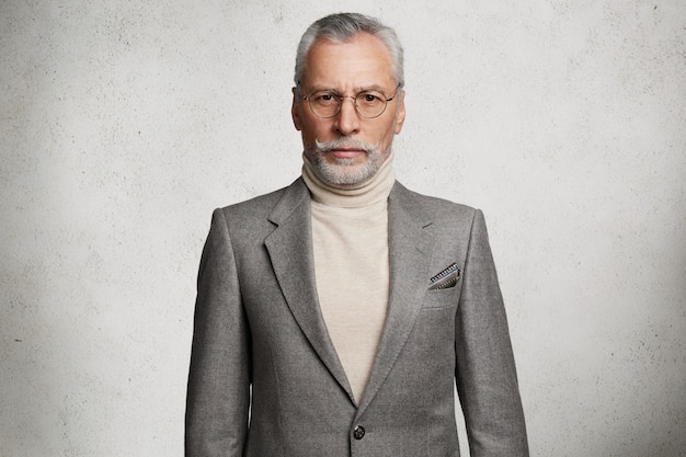 Bärtiger grauhaariger älterer Mann im formellen Anzug