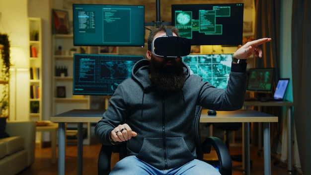 Bärtiger Hacker, der eine Virtual-Reality-Brille trägt. Internet-Kriminelle.