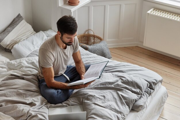 bärtiger Kerl posiert zu Hause während der Arbeit