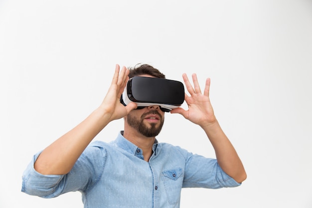 Bärtiger männlicher Benutzer in VR-Gläsern Erfahrung genießend