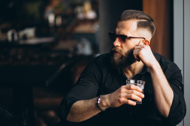 Bärtiger Mann, der in einer Bar trinkt