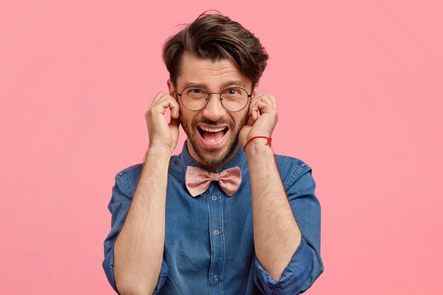 Bärtiger Mann im Jeanshemd und in der rosa Fliege