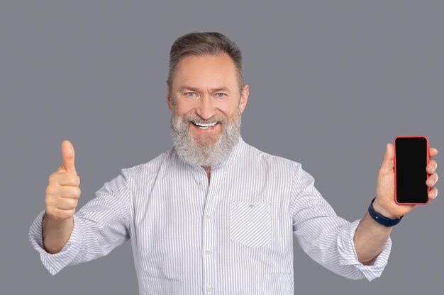 Bärtiger Mann mit Smartphone in der Hand