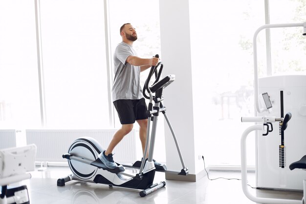 Bärtiger Mann mit Spinbike im Physiotherapieraum