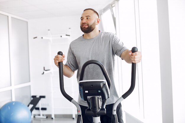 Bärtiger Mann mit Spinbike im Physiotherapieraum