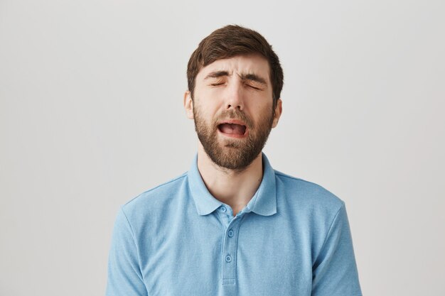 Bärtiges Porträt eines jungen Mannes mit blauem T-Shirt