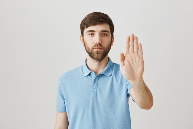 Bärtiges Porträt eines jungen Mannes mit blauem T-Shirt