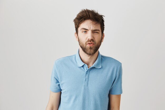 Bärtiges Porträt eines jungen Mannes mit blauem T-Shirt