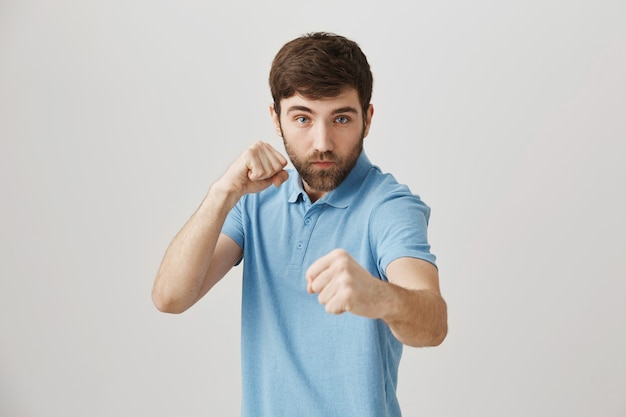 Bärtiges Porträt eines jungen Mannes mit blauem T-Shirt