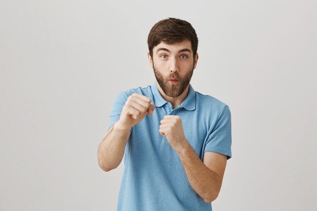 Bärtiges Porträt eines jungen Mannes mit blauem T-Shirt