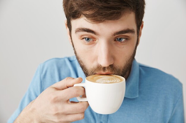 Bärtiges Porträt eines jungen Mannes mit blauem T-Shirt