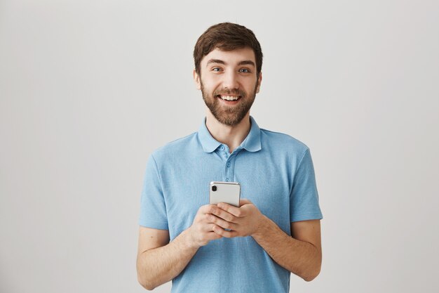 Bärtiges Porträt eines jungen Mannes mit blauem T-Shirt