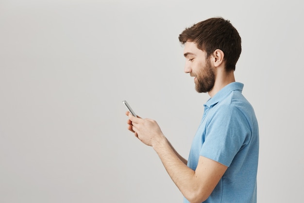 Bärtiges Porträt eines jungen Mannes mit blauem T-Shirt