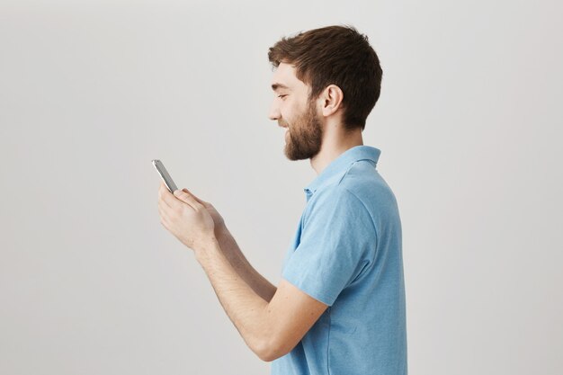 Bärtiges Porträt eines jungen Mannes mit blauem T-Shirt