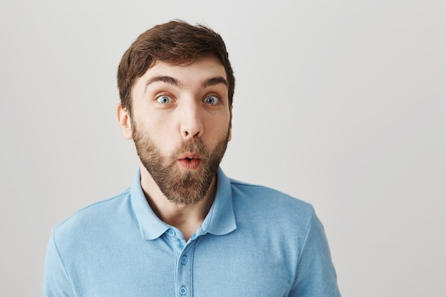 Bärtiges Porträt eines jungen Mannes mit blauem T-Shirt